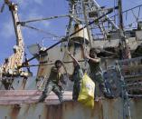 Philippine Marines deployed on the Philippine Navy ship LT 57 Sierra Madre lift sacks of provisions after the Philippine Government vessel AM700 successfully dockied beside it off Second Thomas Shoal, locally known as Ayungin Shoal, Saturday, March 29, 2014 off South China Sea on the West Philippine Sea. China Coast Guard vessel attempted to block the vessel earlier which carried supplies and troops to replace their fellow marines who were deployed for almost five months. (AP Photo/Bullit Marquez)