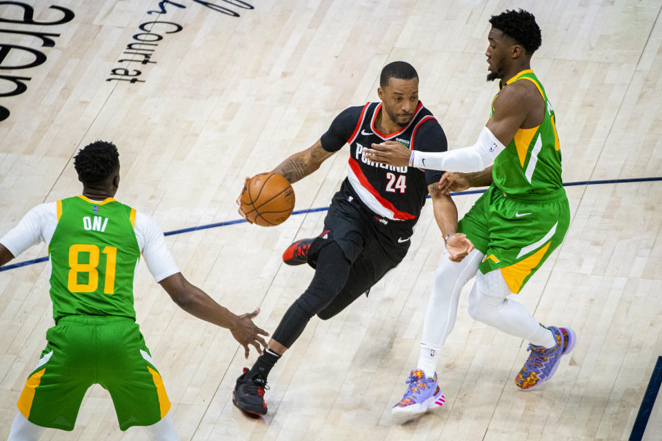 Portland Trail Blazers forward Norman Powell (24) drives the ball on Utah Jazz guard Donovan Mitchell, right, during the first half of an NBA basketball game Thursday, April 8, 2021, in Salt Lake City. (AP Photo/Isaac Hale)