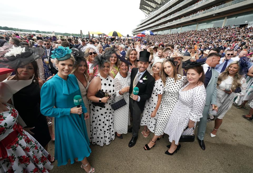 A group of women stand together in polka dot dresses