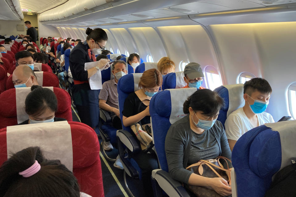 La nueva forma de viajar también se nota durante el vuelo. En la fotografía, una azafata ayuda a un pasajero a completar su historial de viajes en un vuelo de China Eastern Airlines en el Aeropuerto Internacional Shenzhen Baoan de provincia de Guangdong (China). Este documento es obligatorio en el país asiático. (Foto: Martin Pollard / Reuters).