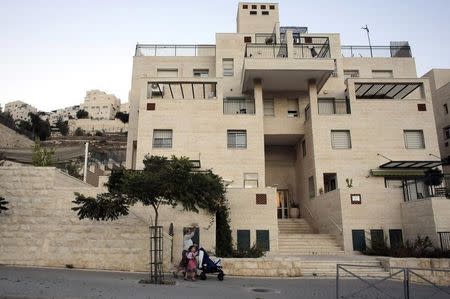 A woman pushes a pram as she walks in a Jewish settlement near Jerusalem known to Israelis as Har Homa and to Palestinians as Jabal Abu Ghneim October 27, 2014. REUTERS/Ammar Awad