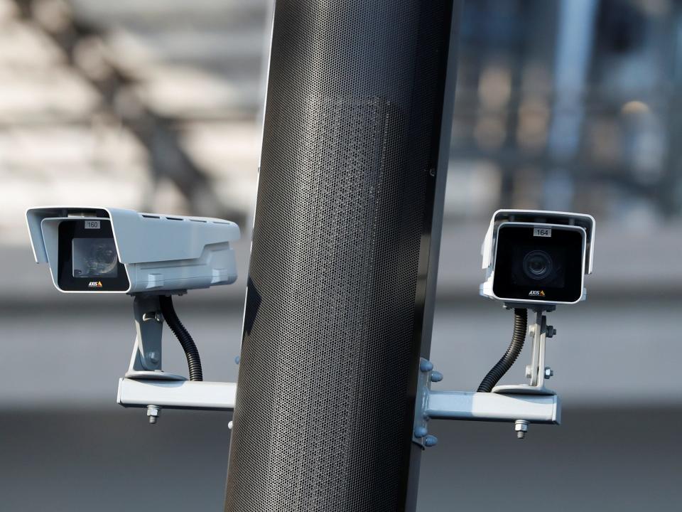 Two security cameras attached to a pole outside.