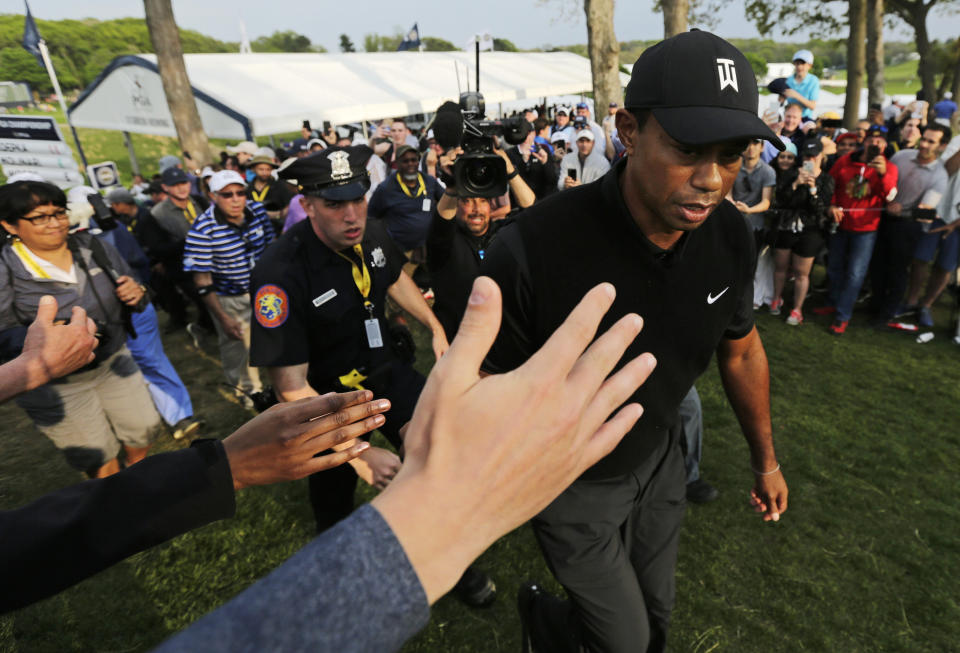 Golf fans reach out to Tiger Woods as he walks to the 18th tee during the second round of the PGA Championship golf tournament, Friday, May 17, 2019, at Bethpage Black in Farmingdale, N.Y. (AP Photo/Charles Krupa)