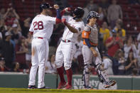 Boston Red Sox's J.D. Martinez, left, celebrates with Xander Bogaerts, center, after they both scored on a two-run home run by Bogaerts in the eighth inning of a baseball game, as Houston Astros' Jason Castro, right, looks on, Monday, May 16, 2022, in Boston. The Red Sox won 6-3. (AP Photo/Steven Senne)