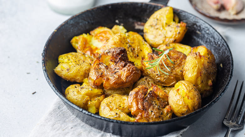 Crispy smashed potatoes in skillet