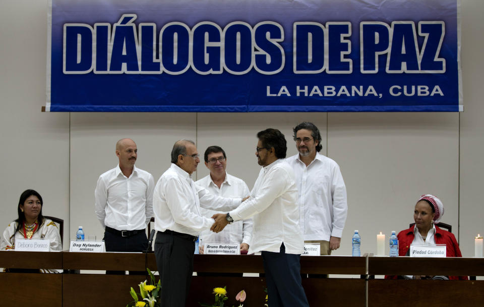 FILE - In this Dec. 15, 2015 file photo, Norwegian diplomat Dag Nylander, second from left, watches as Humberto de la Calle, front left, head of Colombia's government peace negotiation team, shakes hands with Ivan Marquez, chief negotiator of the Revolutionary Armed Forces of Colombia, or FARC, after signing an agreement on how to address the needs of 6 million victims, at Convention Palace in Havana, Cuba. In a 2015 interview with Spain’s El Espanol online newspaper Nylander said a successful mediation requires ¨the will to enter into the process keeping a very low profile, not looking for any publicity either for the process or for Norway.” (AP Photo/Ramon Espinosa, File)