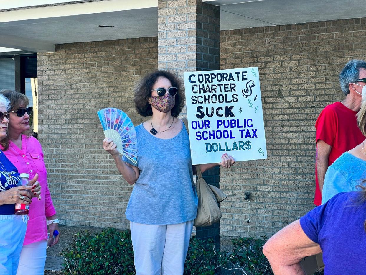 A protester holds a sign calling on the Sarasota School Board to vote down a proposed for-profit charter school Tuesday. The board later voted unanimously to reject the charter school application.