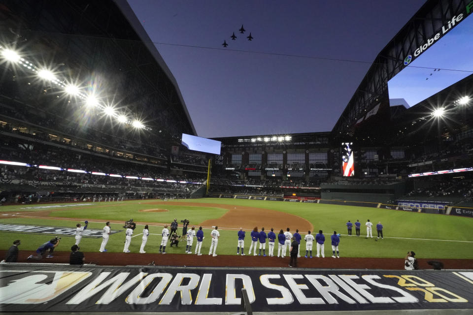 The Los Angeles Dodgers line up during during the national anthem and a fly over before Game 1 of the baseball World Series against the Tampa Bay Rays Tuesday, Oct. 20, 2020, in Arlington, Texas. (AP Photo/Eric Gay)