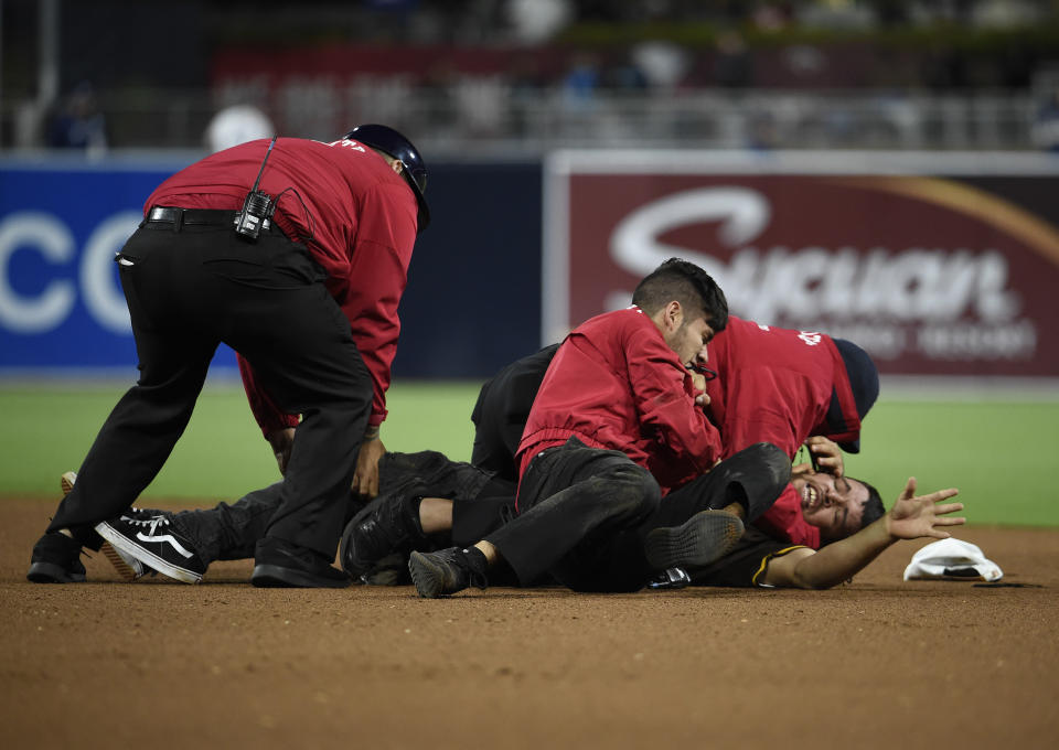 Security guards hold down a fan who ran on the field during the eighth inning of a baseball game between the Miami Marlins and the San Diego Padres at Petco Park June 1, 2019 in San Diego, California. (Photo by Denis Poroy/Getty Images)