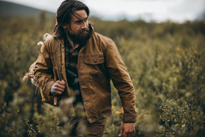 main walking through field in filson jacket