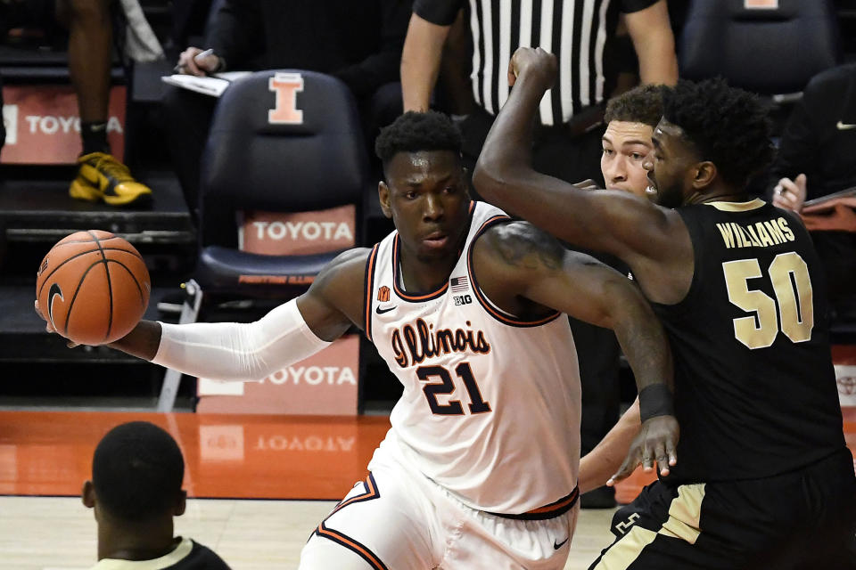 Illinois center Kofi Cockburn (21) does to the basket as he is pressured by Purdue's forward Trevion Williams (50) in the first half of an NCAA college basketball game Saturday, Jan. 2, 2021, in Champaign, Ill. (AP Photo/Holly Hart)