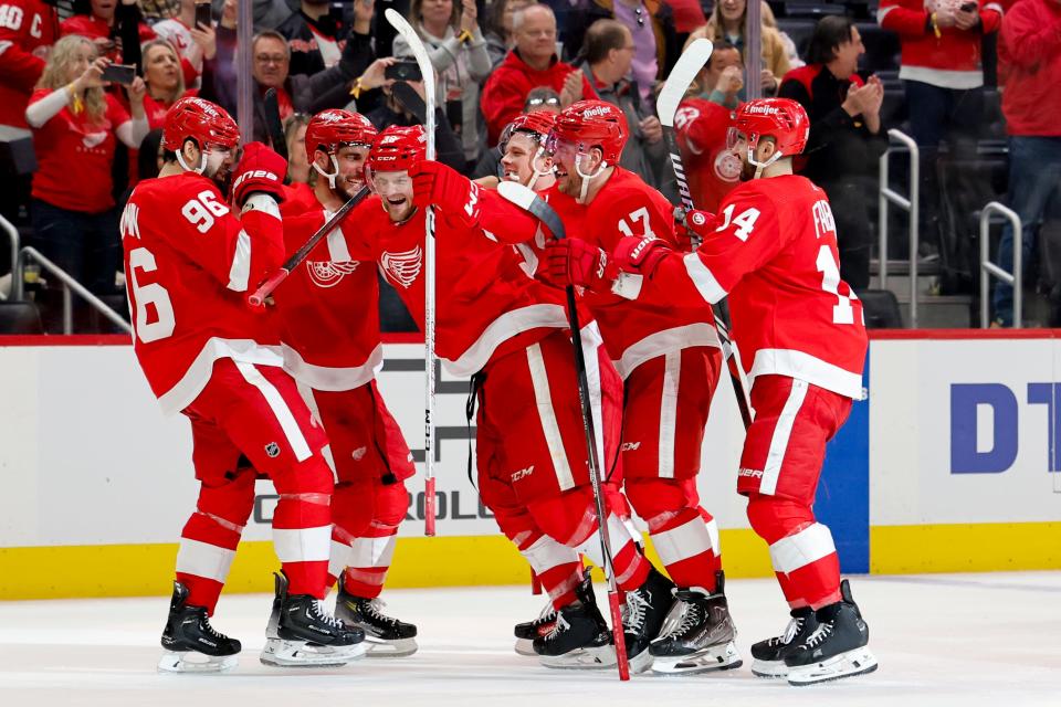 Detroit Red Wings defenseman Jake Walman (96) receives congratulations from teammates after he scores a penalty goal on Vancouver Canucks goaltender Casey DeSmith (29) in overtime at Little Caesars Arena in Detroit on Saturday, Feb. 10, 2024.