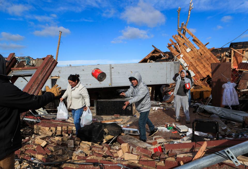 Employees and friends of La Azeteca try to salvage food items after the eatery was destroyed in downtown Mayfield, Ky. after deadly tornados ripped through the small community.  Dec. 11, 2021 