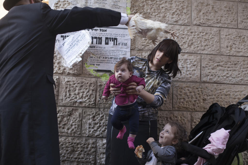 <p>An ultra-Orthodox Jewish man swings a chicken over his family as they perform the Kapparot ceremony on Sept. 27, 2017 in Jerusalem, Israel. It is believed that the Jewish ritual, which involves swinging a live chicken above one’s head, transfers the sins of the past year to the chicken, which is then slaughtered and traditionally given to the poor. It is performed before the Day of Atonement, or Yom Kippur, the most important day in the Jewish calendar, which this year will start on sunset on September 29. (Photo: Lior Mizrahi/Getty Images) </p>