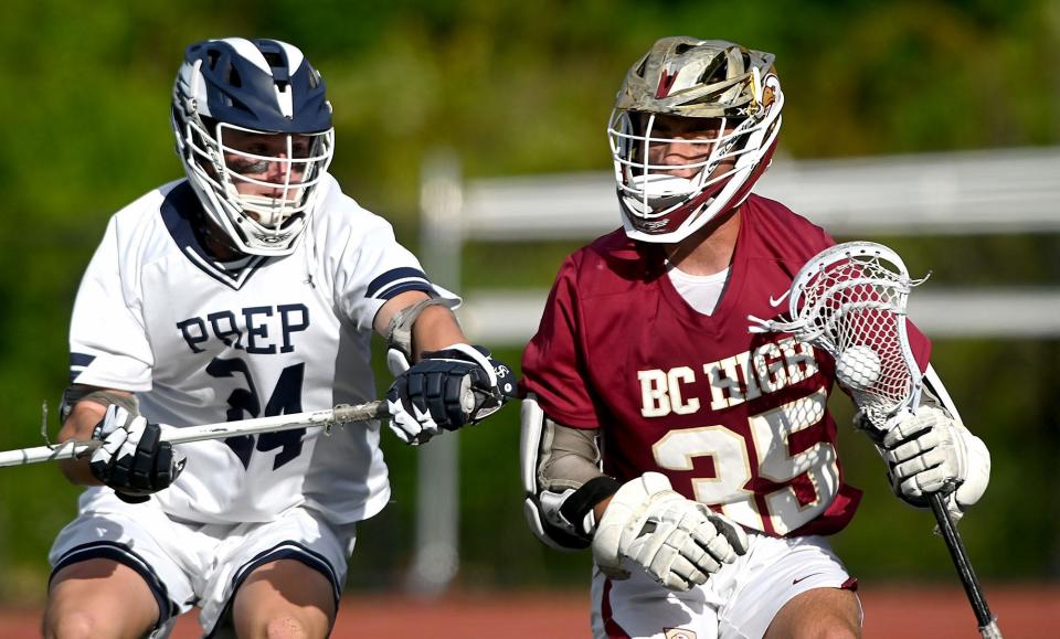 BC High's Will Emsing, right, fends off St. John's Prep's Connor Kelly during the second  half of the MIAA Division 1 boys lacrosse state championship at Worcester State University, June 21, 2022.