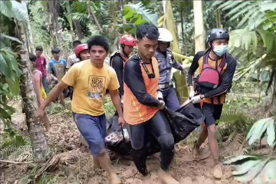 In this image made from video, rescuers carry the body of a victim of a flash flood in Langgai, West Sumatra, Indonesia, Sunday, March 10, 2024. Torrential rains have triggered flash floods and a landslide on Indonesia's Sumatra island leaving a number of people dead and missing, officials said Sunday. (AP Photo)