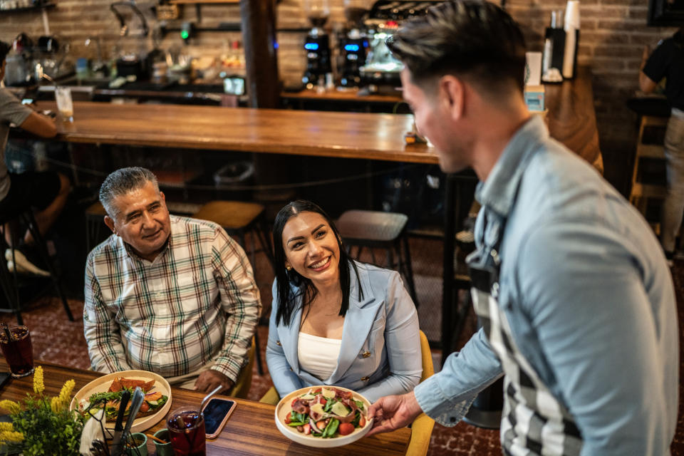 A waiter setting food down for customers