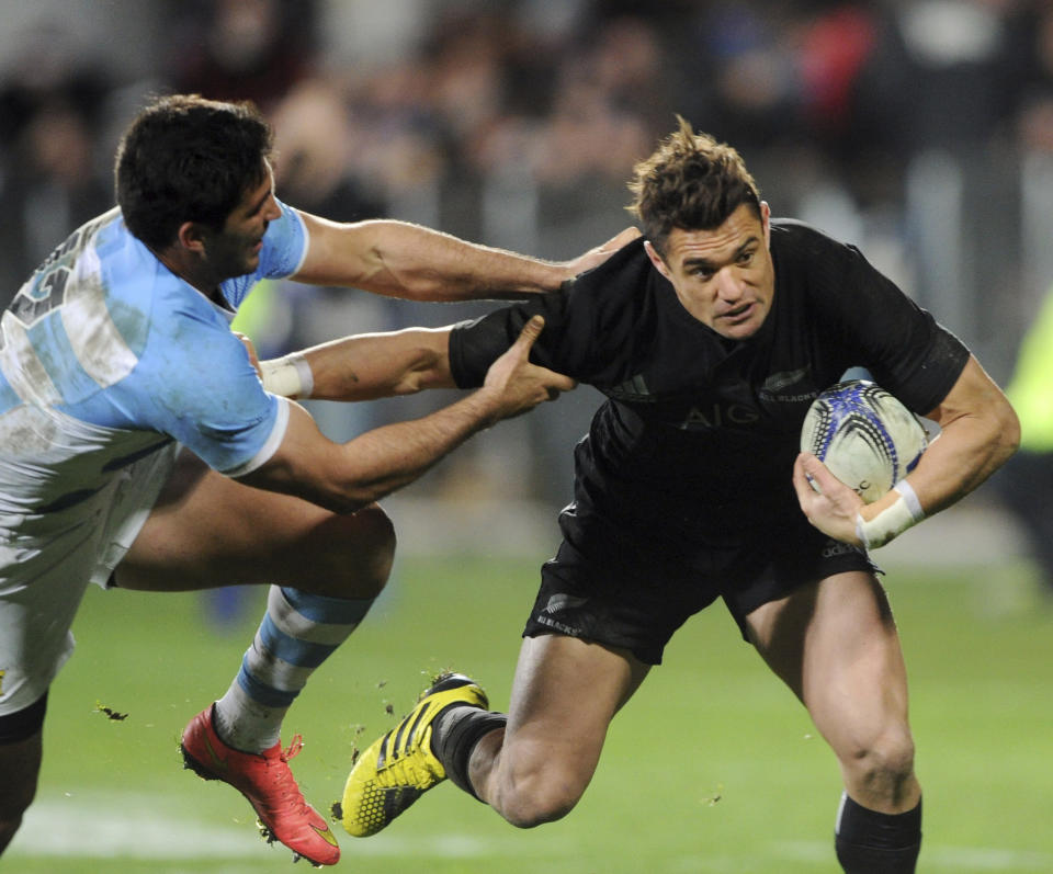 FILE - In this July 17, 2015 file photo, New Zealand All Blacks flyhalf Dan Carter, right, is tackled by Argentina's Jeronimo De la Fuente during their rugby test match in Christchurch, New Zealand. World Cup-winning All Blacks flyhalf Dan Carter is poised to make a surprise return to Super Rugby in New Zealand at the age of 38. Carter is expected to sign on as an injury replacement with the Blues, joining current All Blacks No. 10 Beauden Barrett at the Auckland-based franchise for the upcoming Super Rugby Aotearoa tournament. (AP Ross Setford/SNPA via AP,File)