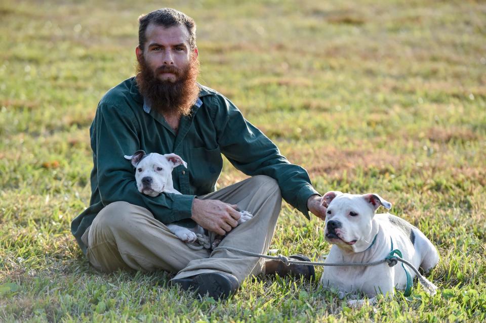 Justin Roland, of Fort Pierce, sits with his dogs, Eva and Xyla, after picking up free meals Wednesday, Feb. 2, 2022, at GraceWay Village in Fort Pierce. Roland has been living in a homeless camp in a wooded area close to GraceWay Village since November of last year.