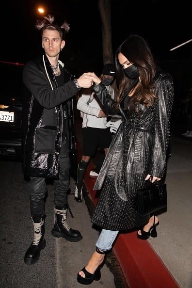 he holds her hand to help her step down from a steep curb