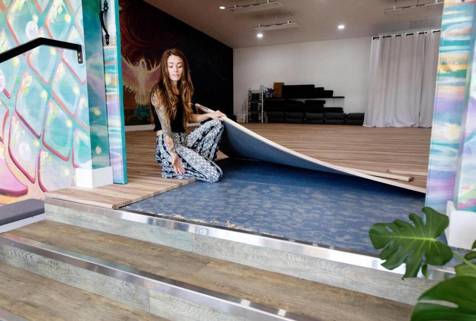 Rebecca Turlay, founder of Oasis Yoga Studio in Kuna, lifts up foam flooring she installed to cover up a local contractor’s unfinished job installing an epoxy floor intended to withstand 100-degree temperatures.