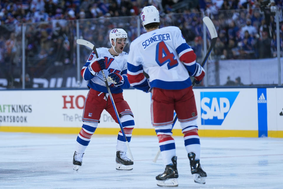 New York Rangers' Erik Gustafsson, left, reacts after scoring during the first period of an NHL Stadium Series hockey game against the New York Islanders in East Rutherford, N.J., Sunday, Feb. 18, 2024. (AP Photo/Seth Wenig)
