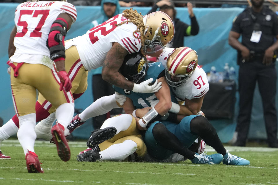 Jacksonville Jaguars quarterback Trevor Lawrence, center, is sacked as San Francisco 49ers defensive end Chase Young (92) and defensive end Nick Bosa (97) defend during the first half of an NFL football game, Sunday, Nov. 12, 2023, in Jacksonville, Fla. (AP Photo/John Raoux)