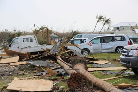 Damaged cars and trucks sit in a field in Treasure Cay, Bahamas