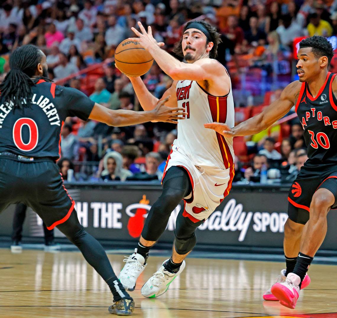 Miami Heat guard Jaime Jaquez Jr. (11) drives to the paint as Toronto Raptors guard Javon Freeman-Liberty (0) and guard Ochai Agbaji (30) defend in the second half during the regular-season finale for the Heat at the Kaseya Center, Miami, Florida on Sunday, April 14, 2024.