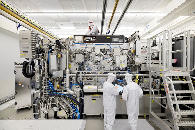 FILE PHOTO: Employees are seen working on the final assembly of ASML's TWINSCAN NXE:3400B semiconductor lithography tool with its panels removed, in Veldhoven