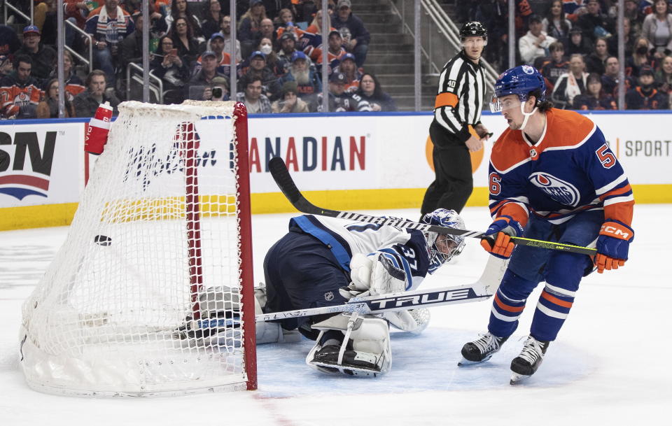Winnipeg Jets goalie Connor Hellebuyck (37) is scored on by Edmonton Oilers' Kailer Yamamoto (56) during the second period of an NHL hockey game Friday, March 3, 2023, in Edmonton, Alberta. (Jason Franson/The Canadian Press via AP)