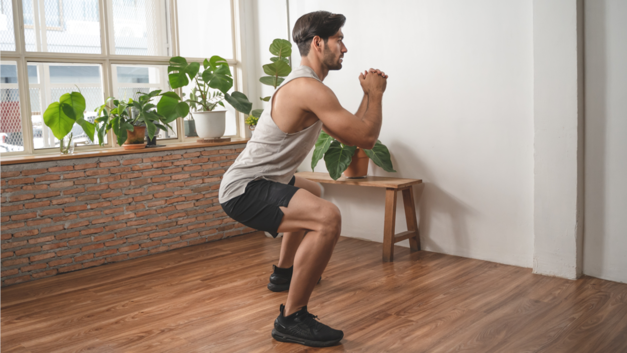  Man doing bodyweight squats. 