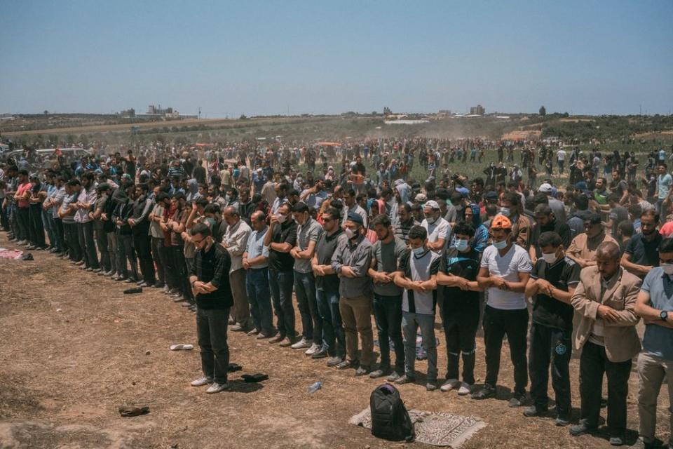 Palestinian men pray along the Gaza-Israel border.