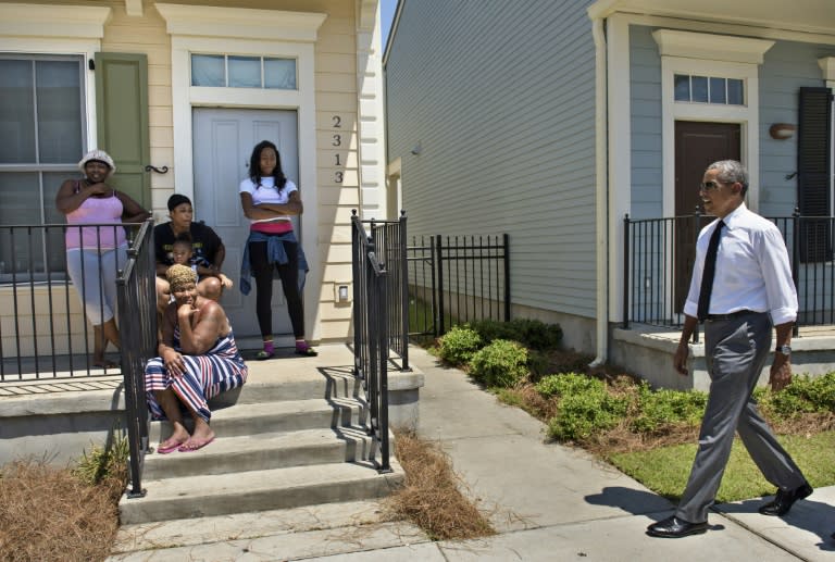 Residents watch as US President Barack Obama walks during a tour of the Treme neighborhood on August 27, 2015 in New Orleans, Louisiana