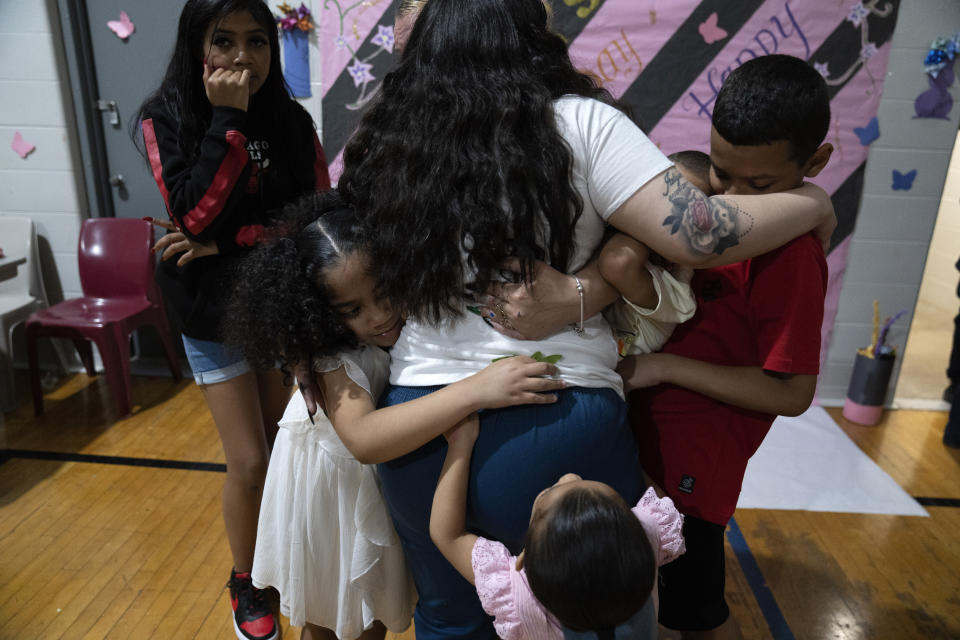 Crystal Martinez, center, is embraced by her five children, clockwise from top left, Nevaeh Martinez, 13, Jayceon Santiago, 5, Reggie Johnson, 10, Jaliyah Santiago, 4, and Myla Martinez, 6, as they prepare to leave her at Logan Correctional Center, Saturday, May 20, 2023, in Lincoln, Illinois. Rare programs like the Reunification Ride, a donation-dependent initiative that buses prisoners' family members from Chicago to Illinois' largest women's prison every month so they can spend time with their mothers and grandmothers, are a crucial lifeline for families, prisoners say. (AP Photo/Erin Hooley)