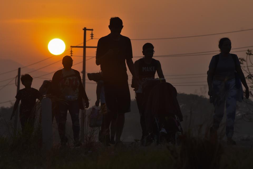 Migrants walk at sunrise along the highway through Arriaga, Chiapas state in southern Mexico, Monday, Jan. 8, 2024, during their journey north toward the U.S. border. (AP Photo/Edgar H. Clemente)