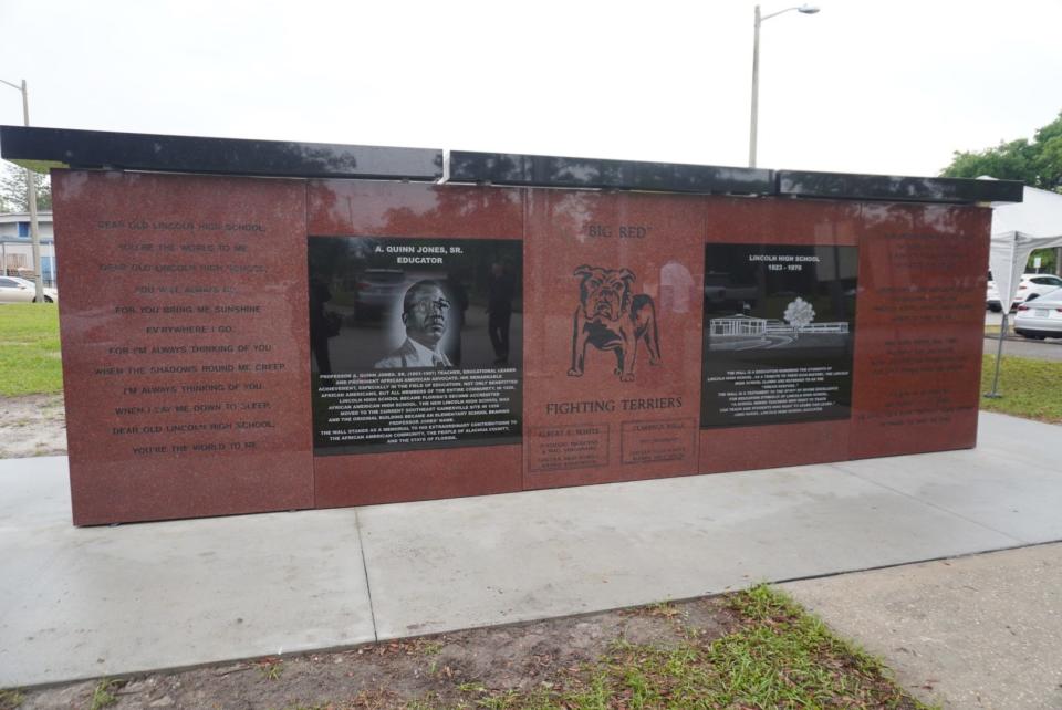 The memorial wall stands by the flagpole in front of Lincoln Middle School. The wall has engraved graphite panels and features two side-by-side plaques: one telling the history of Lincoln High School and the other honoring its founder and former principal, A. Quinn Jones Sr. The memorial wall also features Lincoln High School’s old and new alma mater and the Fighting Terrier, also known as “Big Red.” Beneath the mascot are the names Albert E. White, founding president and wall visionary, and Clarence Mills, the past president.