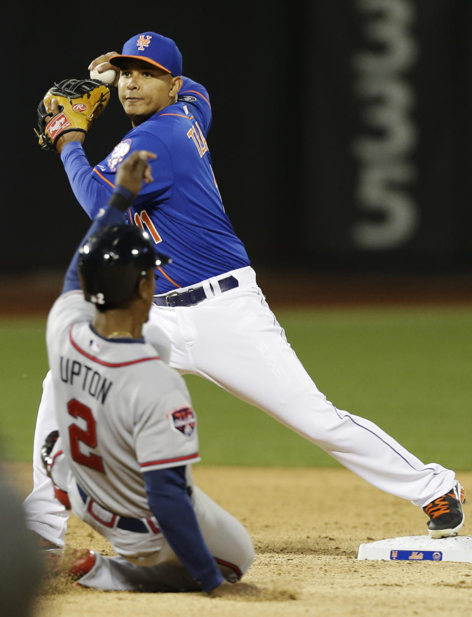 New York Mets shortstop Ruben Tejada, top, throws out Atlanta Braves' Freddie Freeman at first base after forcing out B.J. Upton (2) for a double play during the third inning of a baseball game on Friday, April 18, 2014, in New York. (AP Photo/Frank Franklin II)