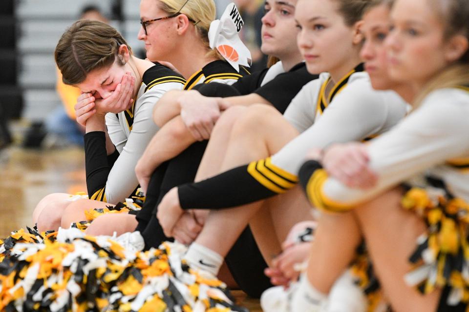 Winterset High School cheerleader Addie Burkett, left, cries during a sendoff celebration Tuesday, March 8, 2022, ahead of the boys basketball team's state tournament game that afternoon against Marion.