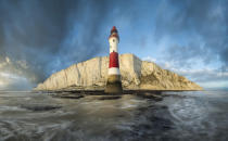 <p>A red and white lighthouse reaches up in front of a rocky outcrop at Beachy Head in East Sussex. (Mirek Galagus)</p><p><br></p>