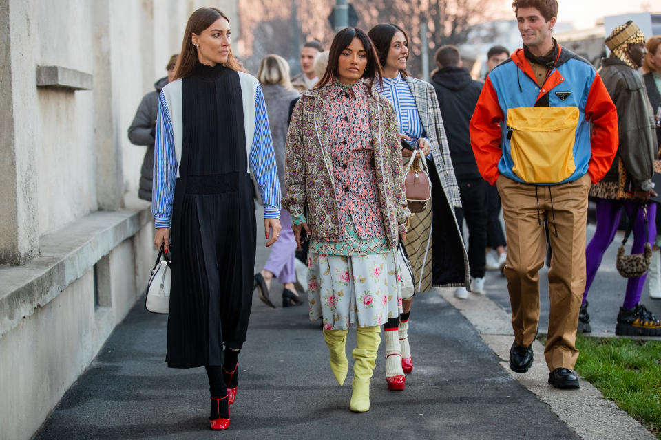 MILAN, ITALY - JANUARY 12: Giorgia Tordini wearing black white blue striped multi colored dress, Amina Muaddi wearing mixed pattern, Gilda Ambrosio wearing Prada bag, yellow skirt, striped button shirt, plaid coat and Marc Forne wearing Prada jacket and brown pants seen outside Prada during Milan Fashion Week Fall/Winter 2020/2021 on January 12, 2020 in Milan, Italy. (Photo by Christian Vierig/Getty Images)