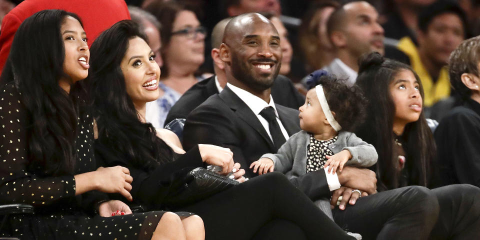 Former Los Angeles Laker Kobe Bryant watches a tribute video with his family during an NBA basketball game between the Los Angeles Lakers and the Golden State Warriors in Los Angeles on Dec. 18, 2017. (Chris Carlson / AP)
