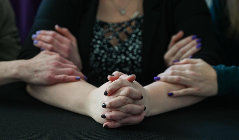 Miranda, a victim of domestic violence, is pictured Monday, Feb. 6, 2024, flanked two women who have been fiercely supportive through her experience.