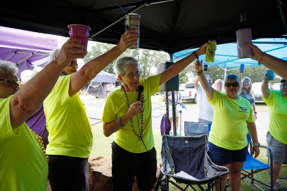 LSU fan Beazie Maurin leads a toast with other LSU fans as they tailgate before a softball game between Tennessee and Alabama in the Women's College World Series at USA Softball Hall of Fame Stadium in Oklahoma City, Thursday, June 1, 2023. 