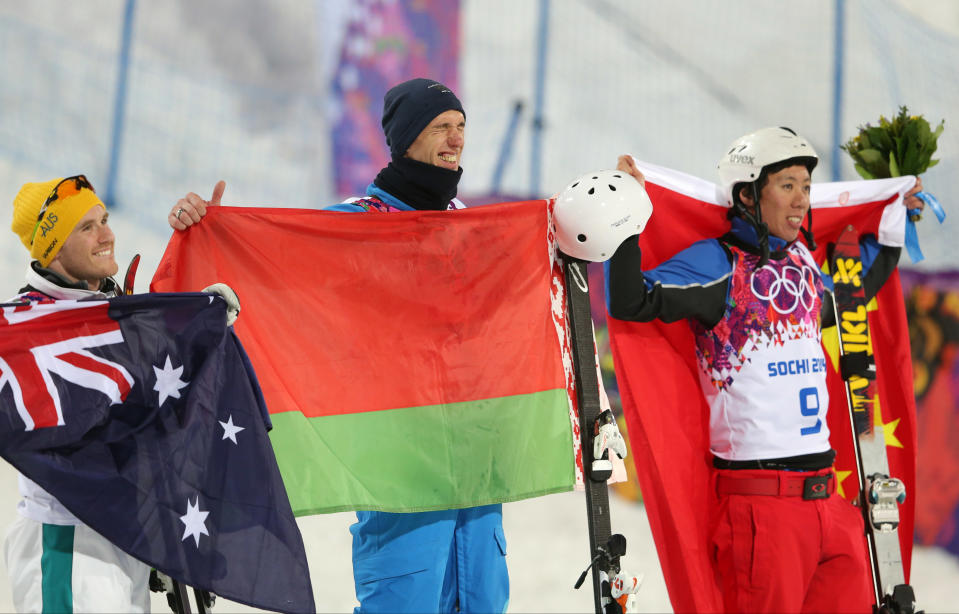 Men's freestyle skiing aerials medalists from left, Australia's David Morris (silver), Anton Kushnir of Belarus (gold), and China's China's Jia Zongyang (bronze), pose for photographers on the podium during a flower ceremony at the Rosa Khutor Extreme Park, at the 2014 Winter Olympics, Monday, Feb. 17, 2014, in Krasnaya Polyana, Russia.(AP Photo/Sergei Grits)