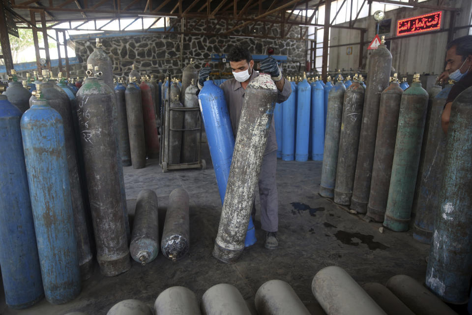 A man works in an oxygen factory in Kabul, Afghanistan, Thursday June 18, 2020. For seven years, Najibullah Seddiqi's oxygen factory sat idle in the Afghan capital Kabul. He shut it down, he says, because corruption and power cuts made it impossible to work. But when the novel coronavirus began racing through his country, he opened the factory's dusty gates and went back to work. Now he refills hundreds of oxygen cylinders a day for free for COVID-19 patients — and at reduced rates for hospitals. (AP Photo/Rahmat Gul)