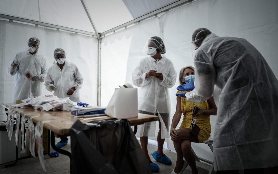 A woman speaks with medical staff during a COVID-19 free screening operation outside the Arcachon railway station - PHILIPPE LOPEZ / AFP