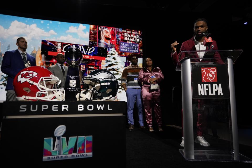 Buffalo Bills' Damar Hamlin speaks after being introduced as the winner of the Alan Page Community Award during a news conference ahead of the Super Bowl 57 NFL football game, Wednesday, Feb. 8, 2023, in Phoenix. At center looking on are Damar Hamlin's parents Mario and Nina Hamlin. At far left is NFLPA President JC Tretter.(AP Photo/Mike Stewart)