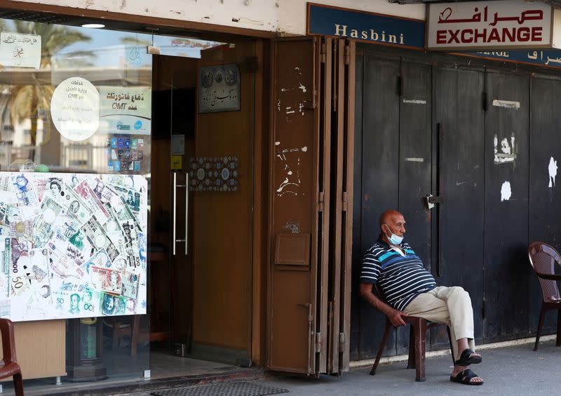 FILE PHOTO: A man sits outside of a currency exchange shop in Beirut