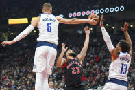 Toronto Raptors guard Fred VanVleet (23) has his shot attempt blocked by Dallas Mavericks center Kristaps Porzingis (6) as Jalen Brunson (13) defends during the first half of an NBA basketball game Saturday, Oct. 23, 2021, in Toronto. (Evan Buhler/The Canadian Press via AP)